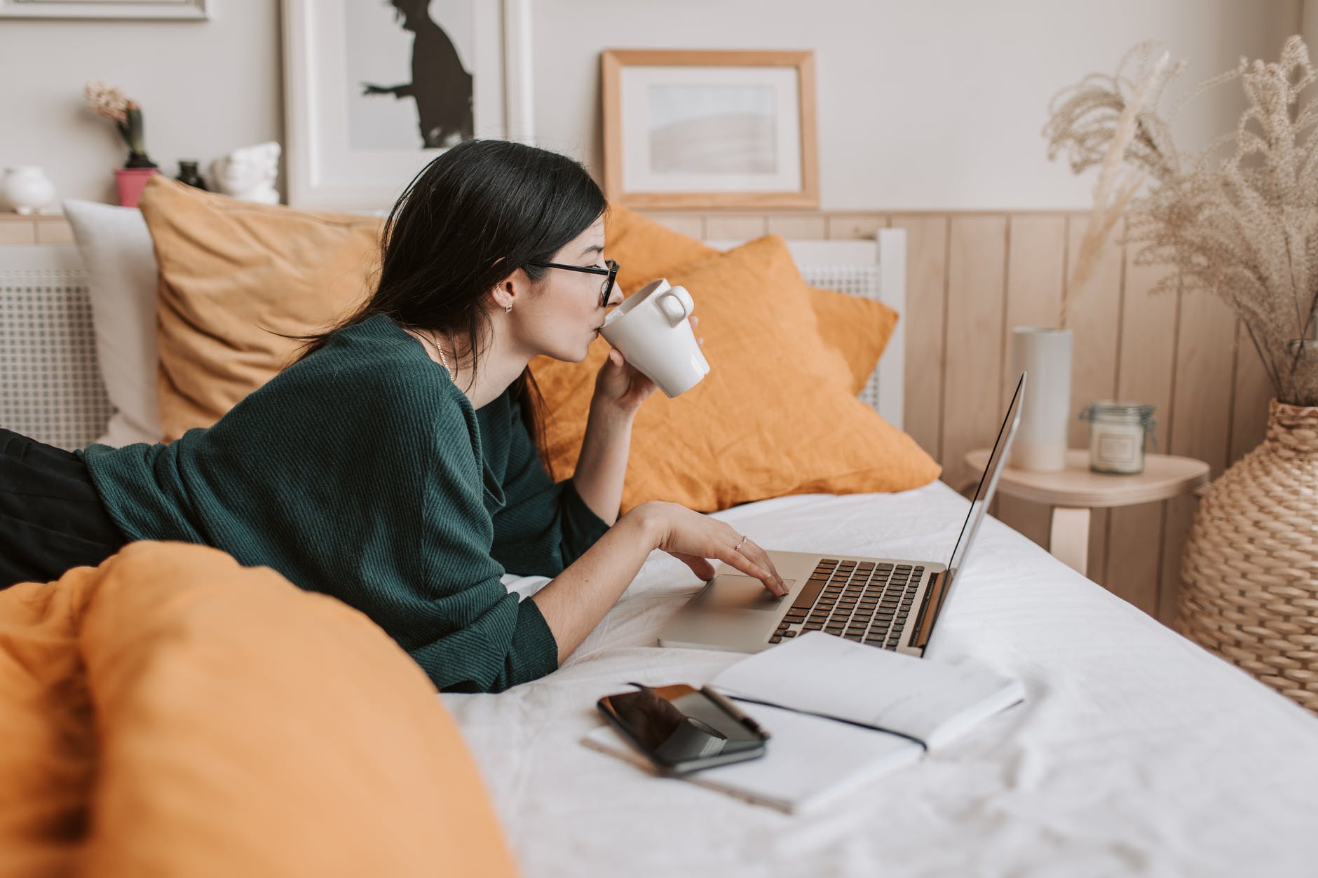 woman using laptop on bed while having online therapy session for anxiety