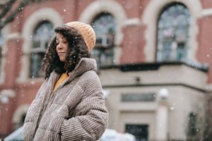 black woman in snowfall in city on college campus 