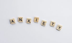 white and brown wooden tiles spelling the word "anxiety" 