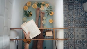 person reading in bath tub for self care to reduce anxiety 