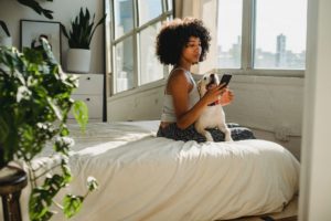 woman with dog and phone preparing for sleep to decrease stress 