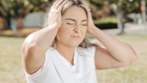 Woman with hands on head to symbolize the stress of having anxiety 