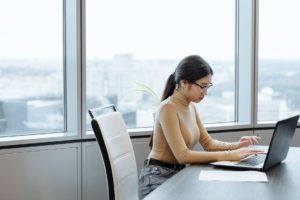 woman in brown long sleeve shirt using laptop for professional self care 